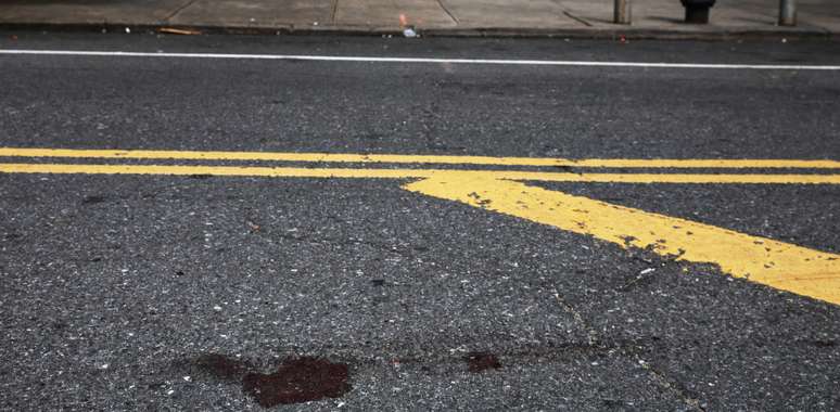 Vest&iacute;gios de sangue no asfalto