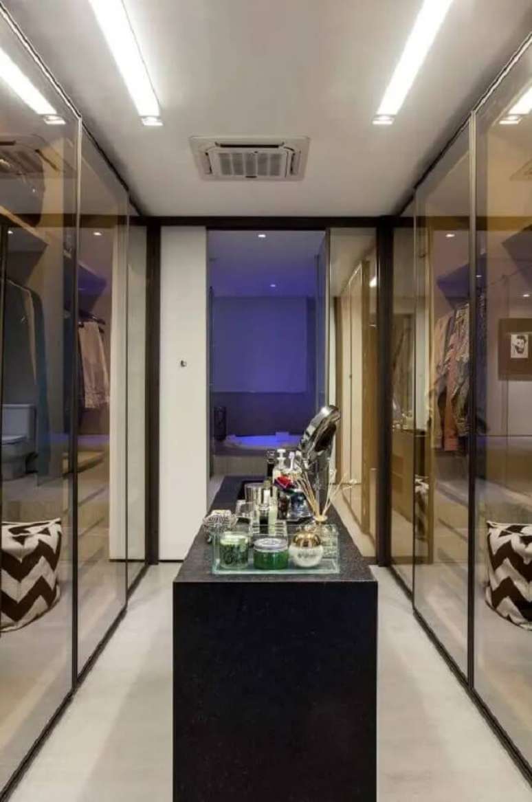 50. Projeto de closet em u com porta de vidro. Fonte: AQ Arquitetura Associados