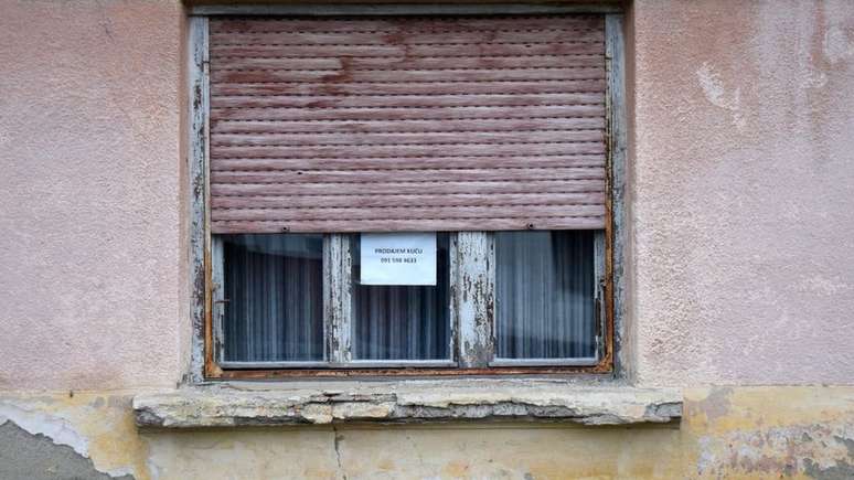 Casa com um aviso de "vende-se" no leste da Croácia