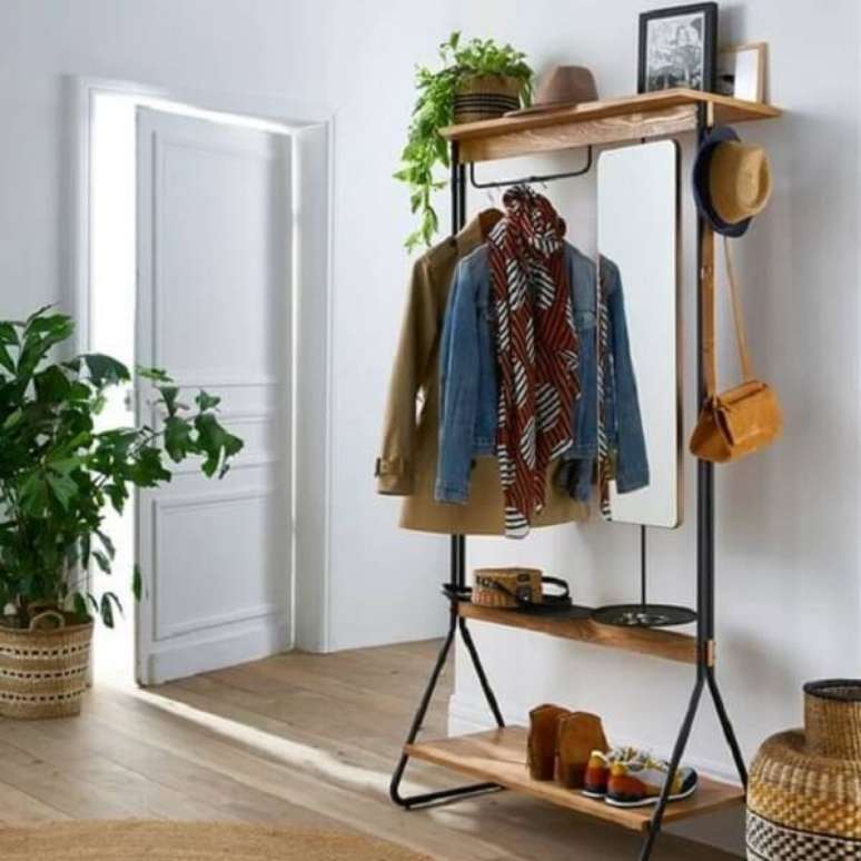 20. Arara de roupas de madeira e ferro com prateleiras no hall de entrada – Foto El Mueblre