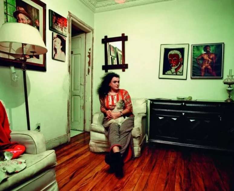 Andréa de Mayo em casa, com quadros ao fundo