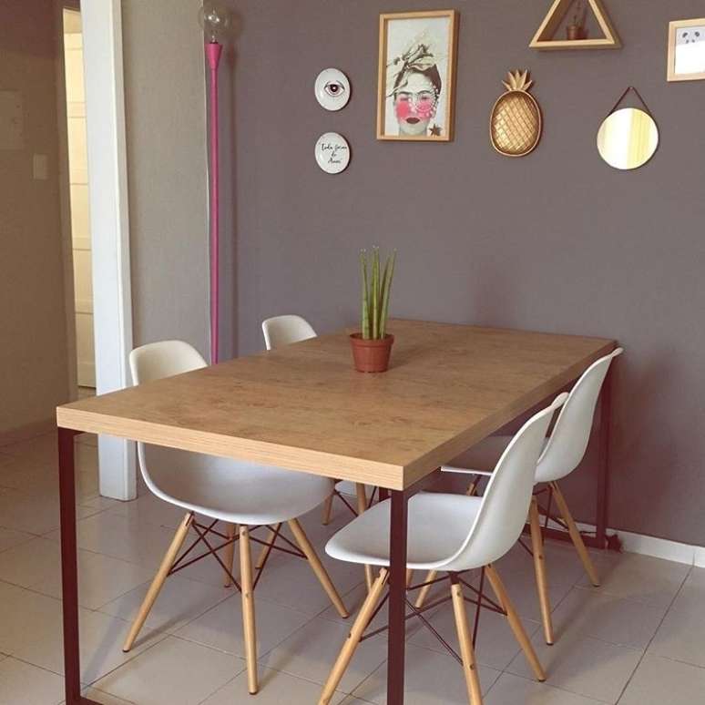 O cinza serve de pano de fundo para a sala de jantar do @apartamento104 e permite a composição de vários elementos diferentes na parede. Repare na luminária rosa ao fundo.