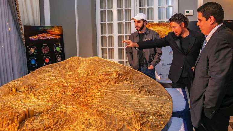 Presidente Nayib Bukele (de boné) observa maquete da cidade planejada Bitcoin City