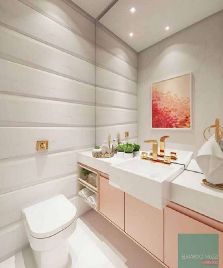 19. Banheiro feminino decorado com gabinete rosa e torneiras douradas dando um toque sofisticado -Foto: Eduardo Muzzi