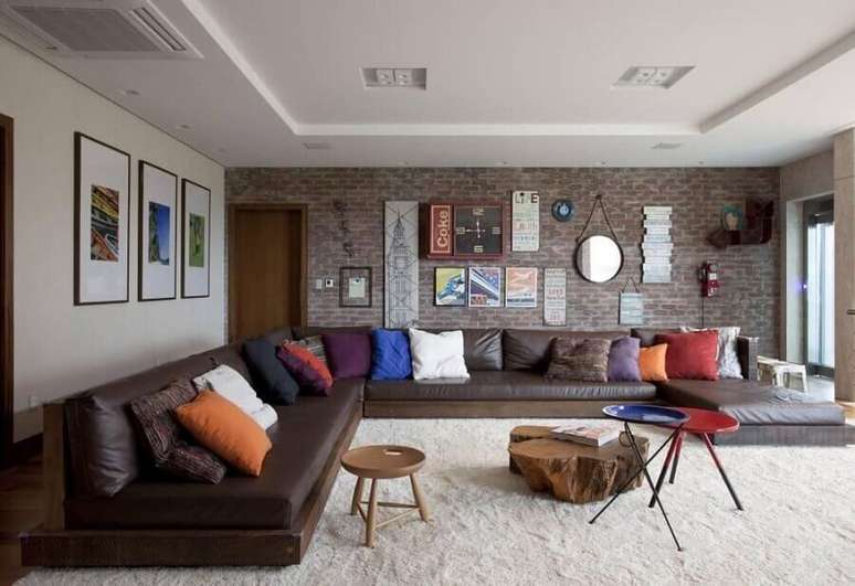 25. Tons terrosos para sala decorada com várias almofadas coloridas para sofá de couro – Foto: Juliana Pippi