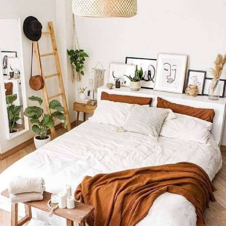 33. Tons terrosos para decoração de quarto branco com vasos de plantas e quadros – Foto: Cassidy Lucille