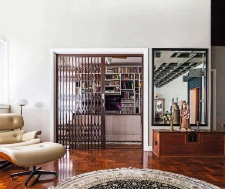 2.A porta pantográfica de ferro separa a sala de estar do restante dos ambientes. Fonte: Revista Casa e Jardim