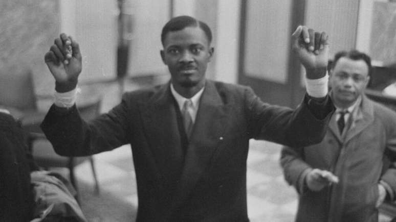 Foto de Patrice Lumumba, ex-primeiro ministro da República Democrática do Congo. Ele é um homem negro e veste terno e gravata.