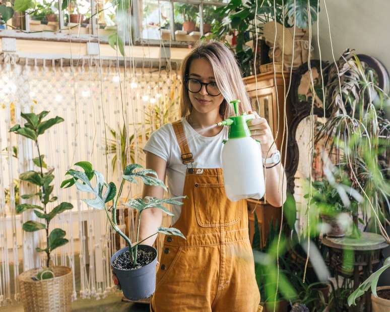Young woman caring for plants in a small shop