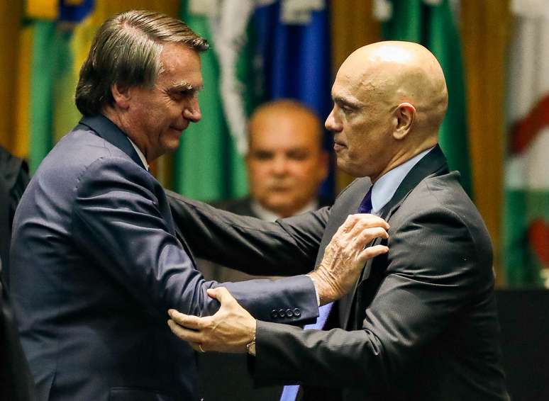 O presidente Jair Bolsonaro e o ministro Alexandre de Moraes se cumprimentam em cerimônia 