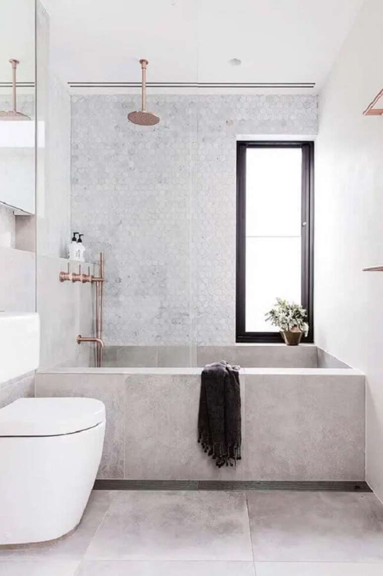6. Banheiro com banheiro e chuveiro de teto rose gold. Fonte: Mi Casa