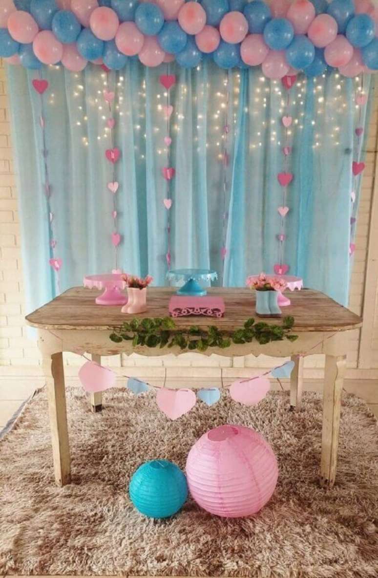 36- O chá revelação simples tem balões rosa e azuis prendendo a cortina. Fonte: Amo Decorar