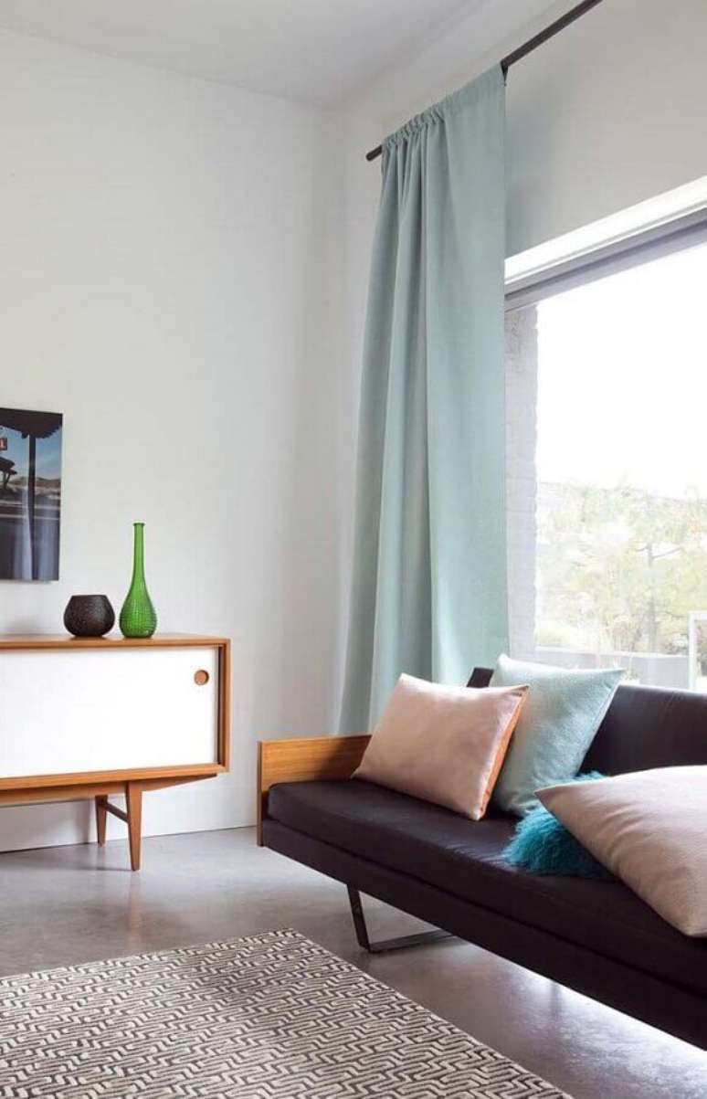 63. Sala minimalista decorada com sofá preto e cortina azul pastel – Foto: Apartment Therapy