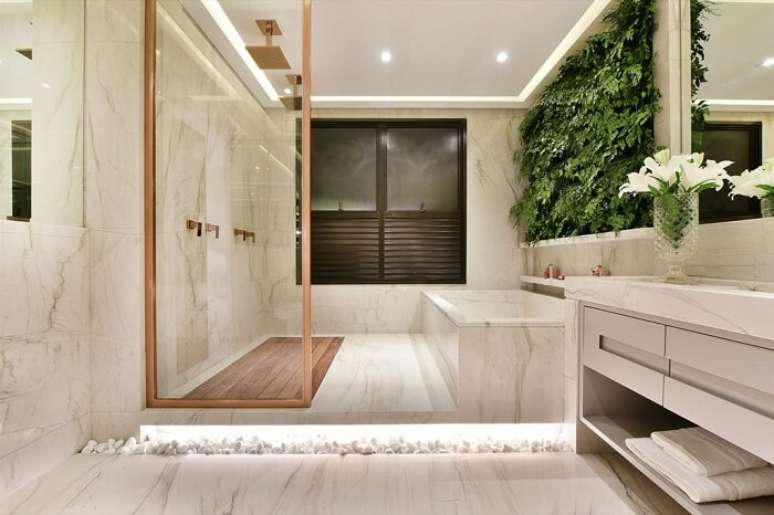 2. Banheiro chique com parede de plantas e chuveiro de teto dourado. Fonte: Arkpad