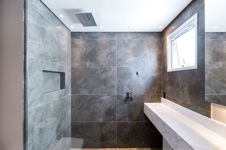 57. Banheiro com revestimento cinza e chuveiro de teto embutido. Fonte: Bibiana Menegaz Arquitetura de Atmosfera
