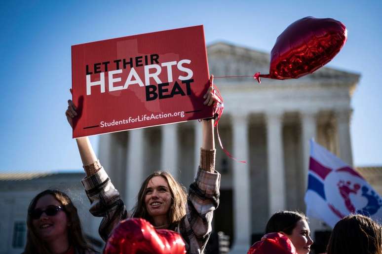 Manifestante antiaborto segura placa que diz "deixe seu coração bater" do lado de fora do Capitólio, em Washington