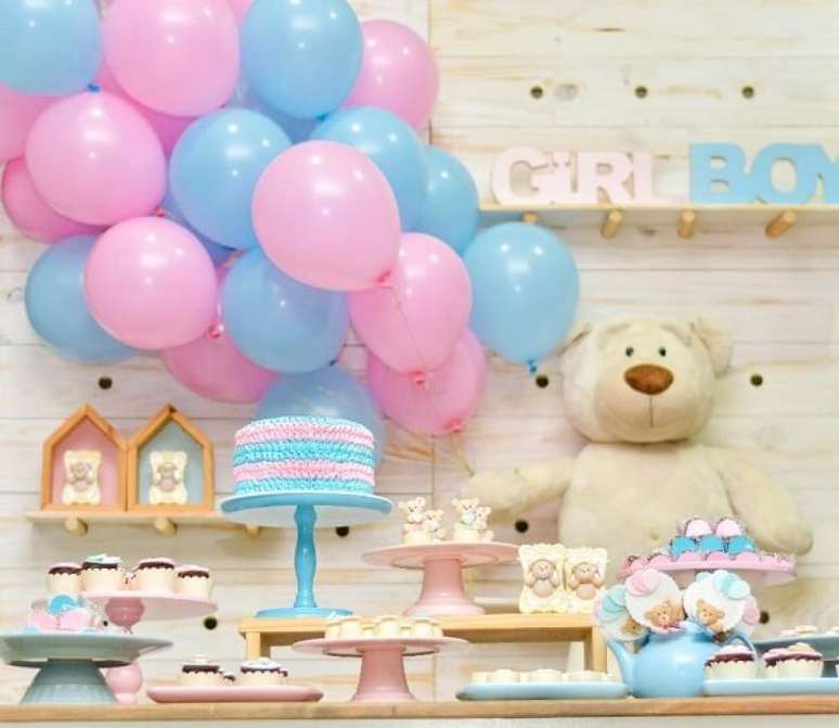 79- As travessas e pratos de bolo mesclam diferentes alturas na mesa do ch&aacute; revela&ccedil;&atilde;o. Fonte: Era O Que Faltava