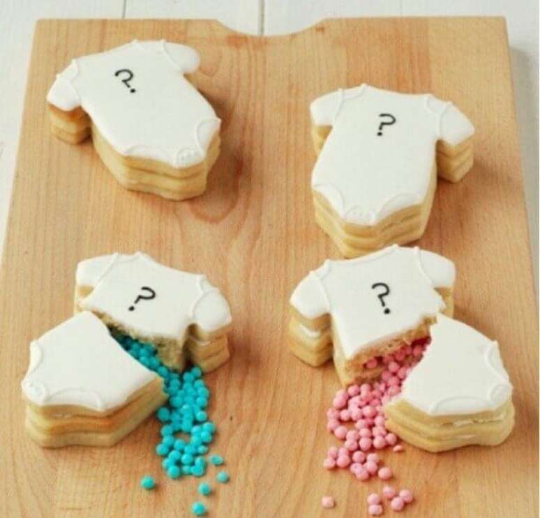 18- Os biscoitos com formato de roupinhas t&ecirc;m recheio de confeitos rosa e azul na mesa do ch&aacute; revela&ccedil;&atilde;o. Fonte: Casa e Festa