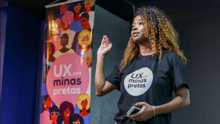 Imagem de Karen Santos, fundadora da UX para Minas Pretas. Ela é uma mulheres negra e tem cabelos cacheados.