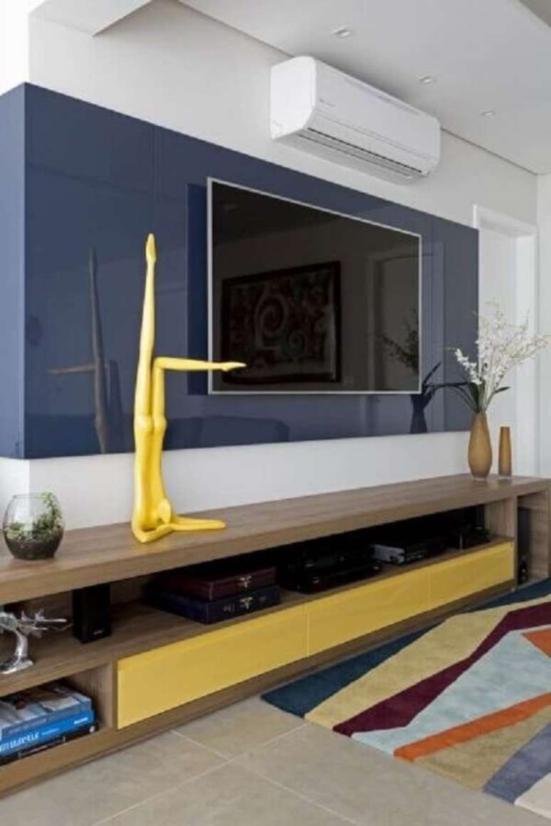 32. Enfeites para sala com rack de madeira e painel azul &ndash; Foto: Allen Roth HQ