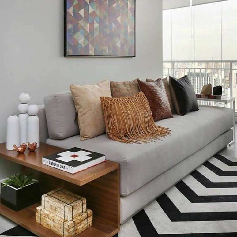 28. Decoração com enfeites para sala com tapete preto e branco, sofá cinza e muitas almofadas – Foto: We Heart It