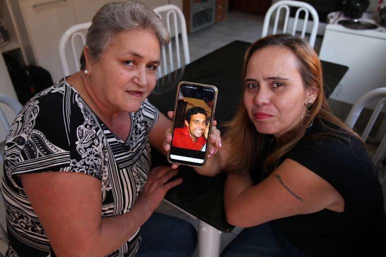 Maria Teresa Lopes e a filha Michele exibem a foto de André, já falecido, que foi entregue para adoção quando era bebê.