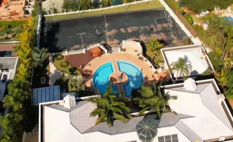 Vista aérea da parte externa da mansão com piscina, campo de futebol e mais áreas de lazer (Foto: Reprodução/Band)