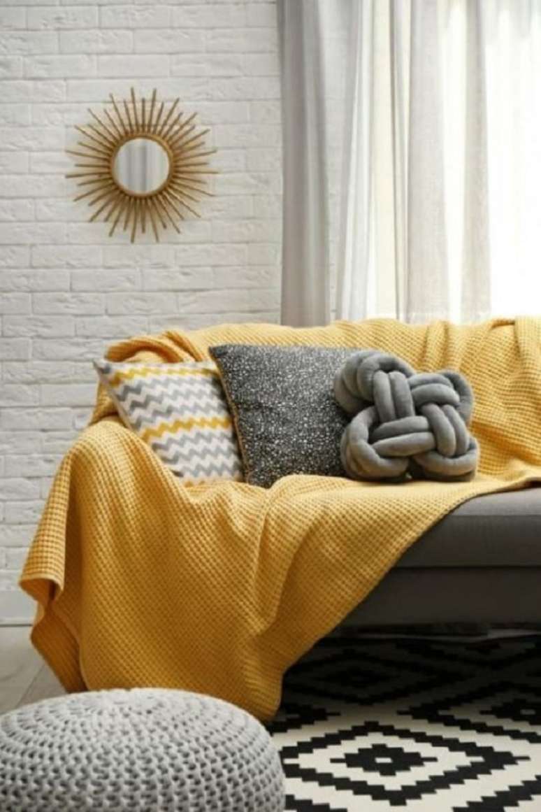24. Sala moderna com sofá cinza e manta amarela – Foto Almanaque da Mulher