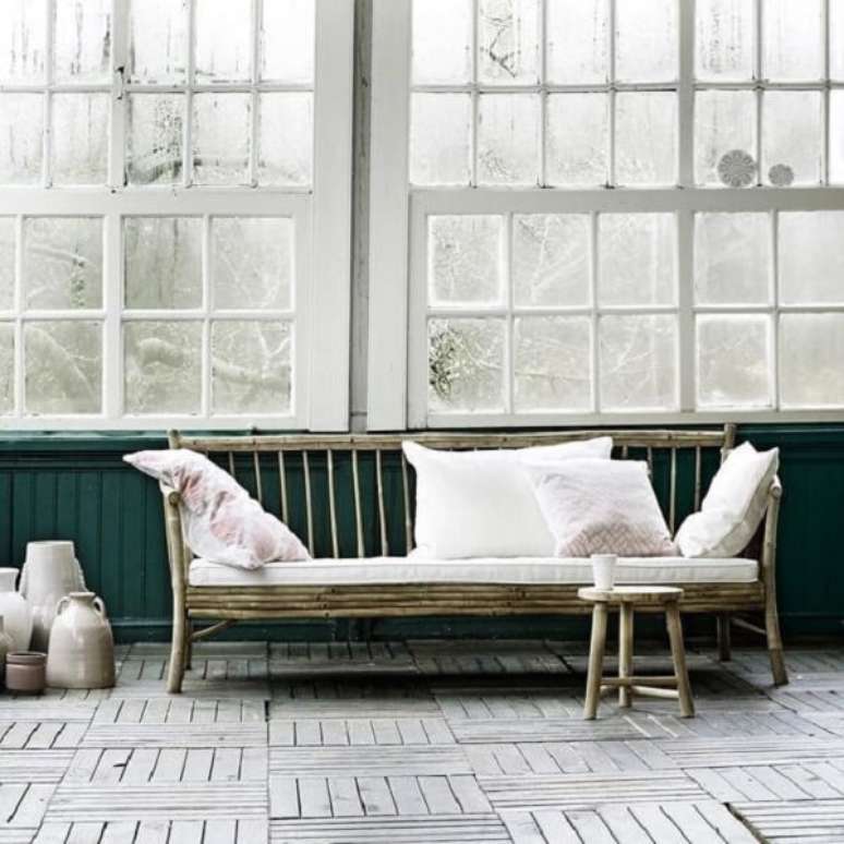 13. Almofadas brancas e sofá de bambu para sala. Fonte: Komodo House