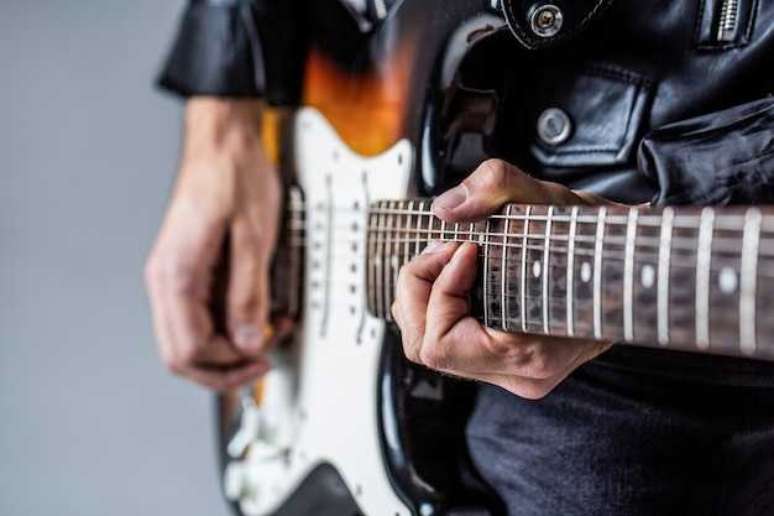 Guitarrista puxando um bend a partir da 12&ordf; casa, onde h&aacute; dois pontos de marcadores de posi&ccedil;&atilde;o (Foto/Freepik)