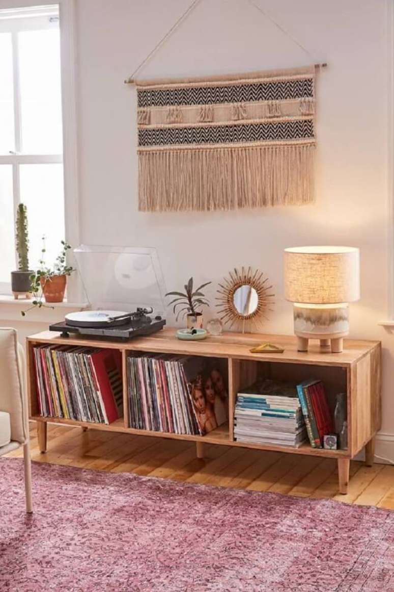 23. Decoração aconchegante com rack de madeira e tapeçaria de parede. Fonte: Urban Outfitters