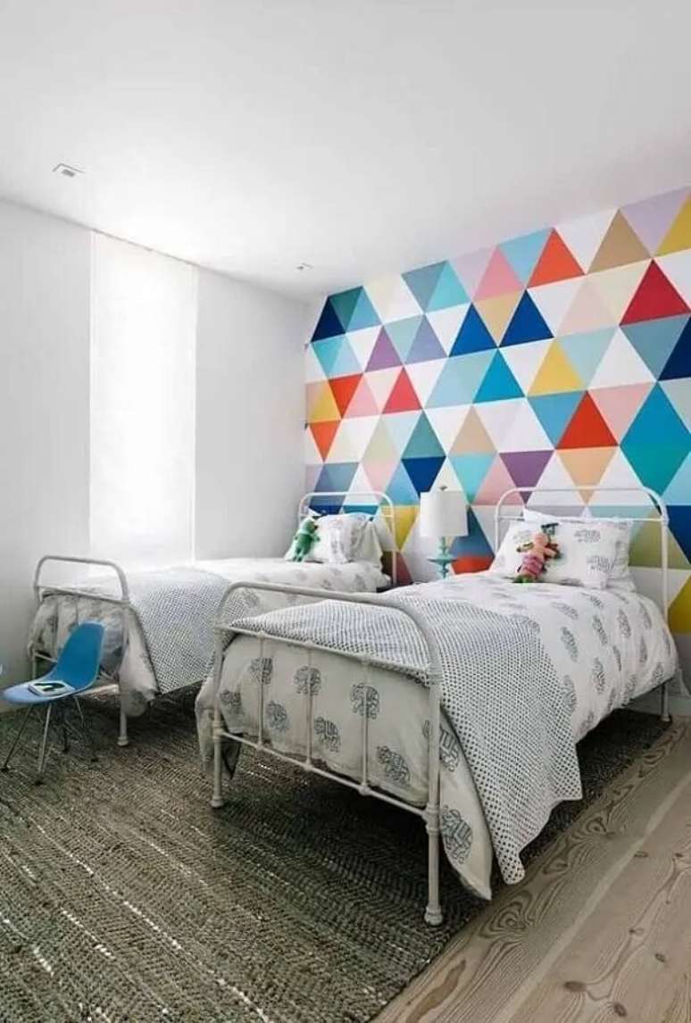 27. Pintar parede com fita crepe quarto com camas de ferro e parede com pintura geométrica colorida. Fonte: 33Decor