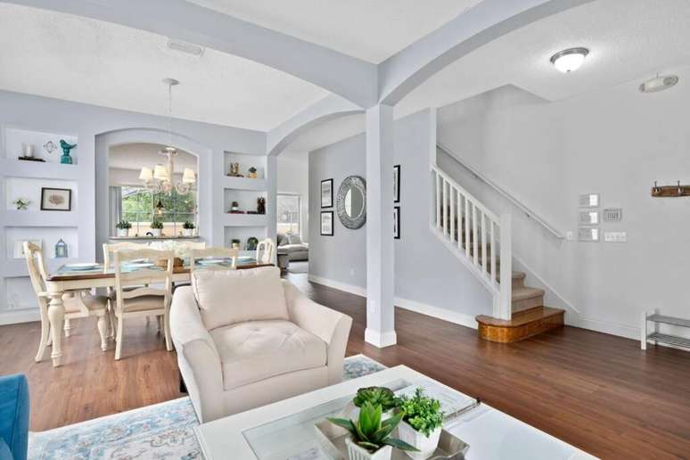 Arcos e colunas d&atilde;o o charme na sala de estar da vila.