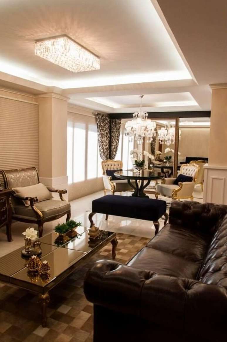 67. Sala de estar com mesa de centro e sof&aacute; de couro. Projeto por Graziela Von Muhlen