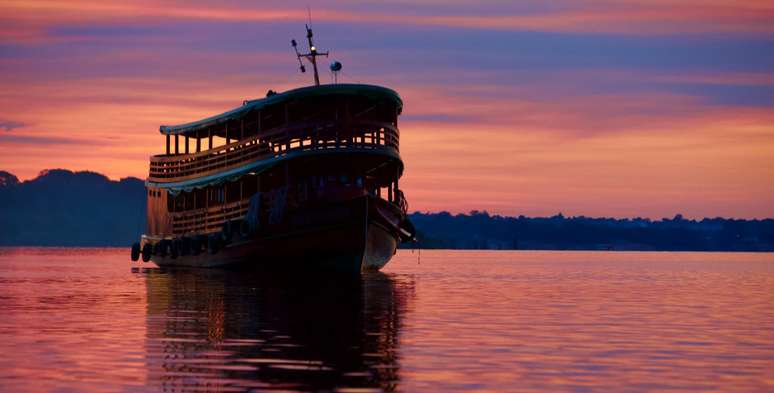 O contorno do barco no nascer do sol amazonense.