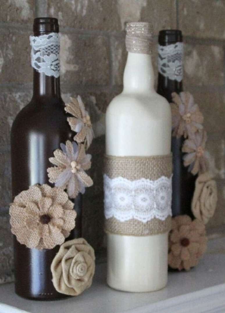 79. Garrafas decoradas com renda e flores de juta. Fonte: Decorei