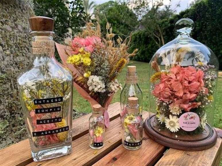 72. Garrafas decoradas com flores naturais para uma decora&ccedil;&atilde;o mais delicada. Fonte: @flordemariaarranjos