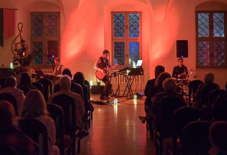 Trio de violão, teclado e bateria se apresentando em uma missa (Foto/Pexels)