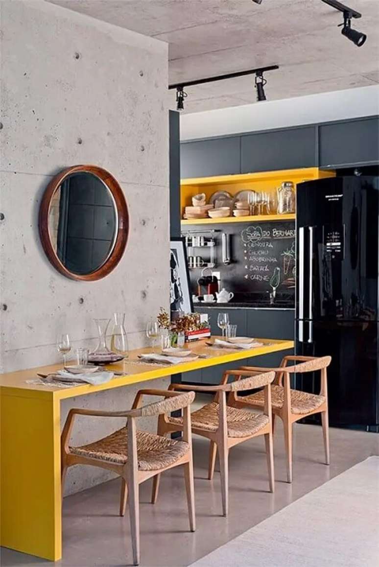 2. Cozinha preta e cinza com bancada amarela e geladeira preta. Fonte: Andrea Pimentel