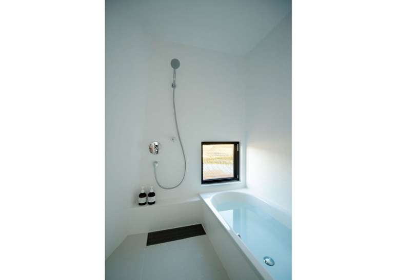 Kiritoshi House, Jap&atilde;o, por Sugawaradaisuke: uma sala molhada toda branca &eacute; pontuada por uma janela quadrada nesta casa japonesa projetada pelo est&uacute;dio de arquitetura Sugawaradaisuke, com sede em T&oacute;quio. Ao lado de uma banheira branca foram instalados um chuveiro e um banco embutido, que &eacute; orientado para que o usu&aacute;rio possa tomar banho e olhar pela janela localizada ao p&eacute; da unidade.