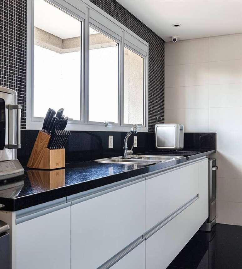 7. A cozinha traz arm&aacute;rios de laminado branco e bancada de granito. Foto: Maura Mello