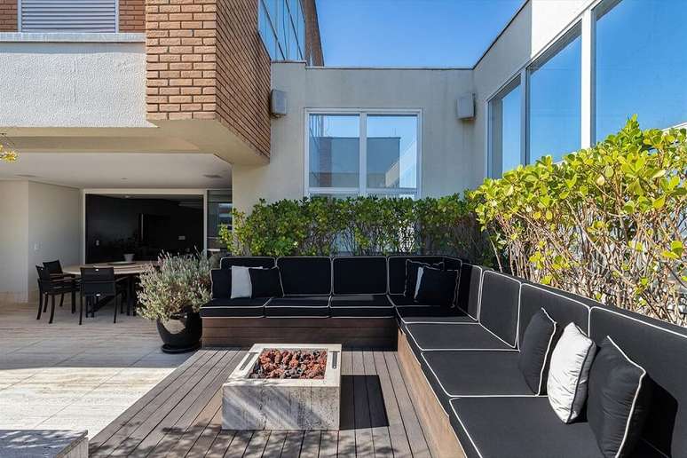 15. A &aacute;rea da piscina tem deck com futon e lareira. Foto: Maura Mello