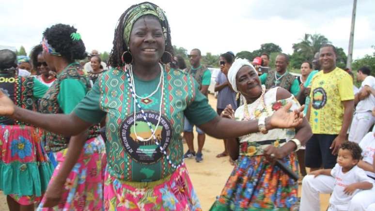 Imagem de comunidade quilombola em festa no Extremo Sul da Bahia. Pessoas estão dançando.