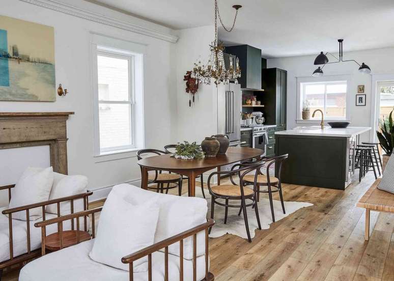 Possui uma área entre a cozinha e a sala de estar? Considere torná-la sua sala de jantar formal. Estabeleça uma separação clara entre os aposentos posicionando a mesa e as cadeiras sob um tapete e pendurando um lustre acima.