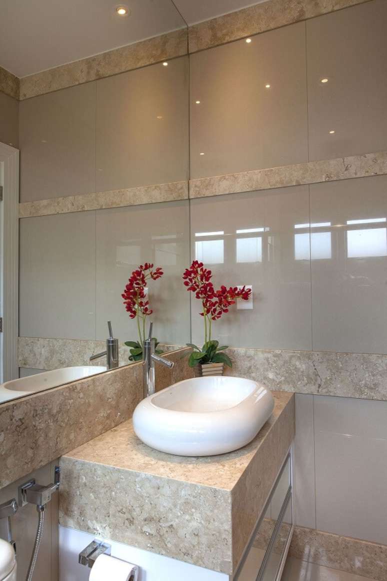 23. Banheiro bege com cuba de apoio branca e flores &ndash; Foto Iara Kilaris