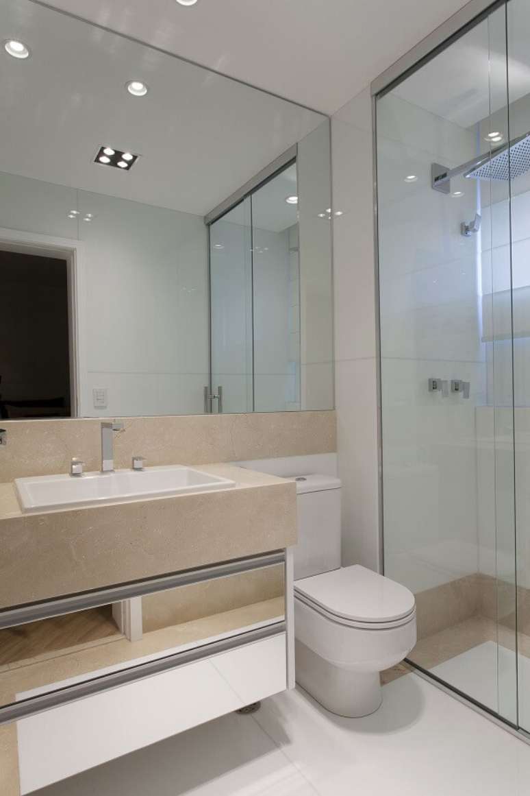71. Pia de banheiro de mármore bege com espelho na parede – Foto Iara Kilaris