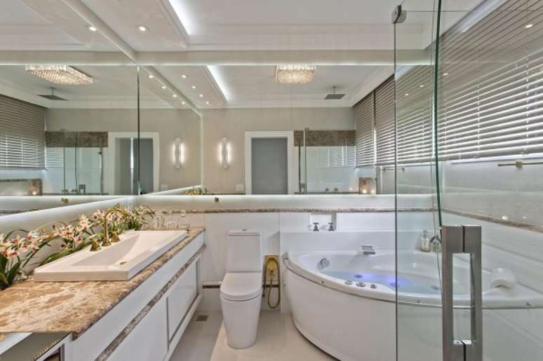 41. Banheiro bege e branco com flores atr&aacute;s da bancada &ndash; Foto Aquiles Nicolas Kilaris