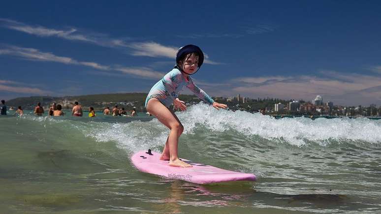 Menina surfando na Freshwater Beach em Sydney, na Austrália
