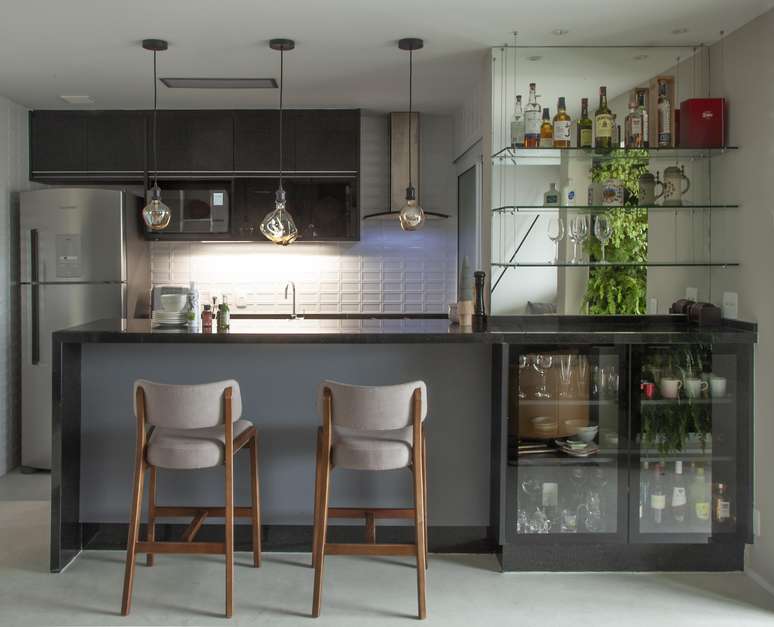 Nessa cozinha, a arquiteta optou por tomadas atras do mobiliário, destinadas aos eletrodomésticos, sem deixar de lado o cantinho do café, que conta com uma máquina, trazendo praticidade para o dia a dia.