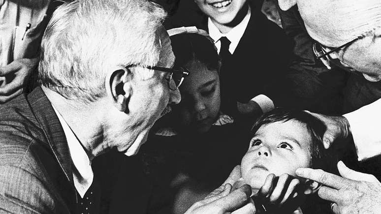 Albert Sabin, médico pesquisador que desenvolveu a vacina oral contra a poliomielite, pede ao menino Luiz Inácio Gama, de cinco anos, que abra bem a boca no hospital antipoliomielite Jesus, no Rio de Janeiro, em 1967